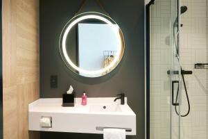 霍夫多普Moxy Amsterdam Schiphol Airport的浴室设有白色水槽和镜子