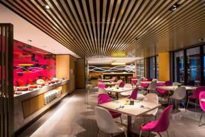 台北台北北投雅乐轩酒店的配有桌椅和粉色椅子的餐厅
