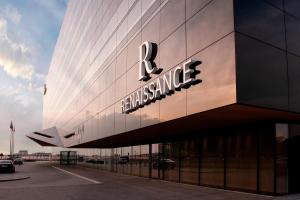 华沙Renaissance Warsaw Airport Hotel的建筑的侧面有标志