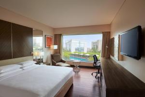 孟买孟买国际机场万豪度假酒店的一间酒店客房,设有一张大床和一个大窗户