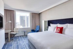 悉尼悉尼港环形码头万豪酒店的酒店客房设有一张大床和一张书桌。