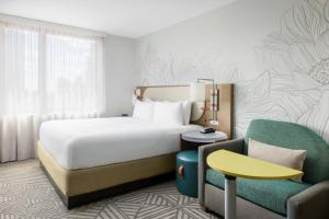纽约SpringHill Suites by Marriott New York Manhattan Chelsea的配有一张床和一把椅子的酒店客房