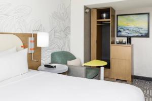纽约SpringHill Suites by Marriott New York Manhattan Chelsea的酒店客房配有一张床、一把椅子和一台电视。