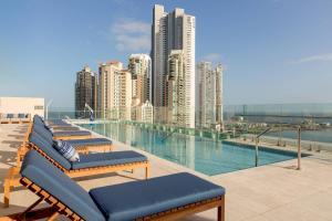 巴拿马城Residence Inn by Marriott Panama City的游泳池旁的一排躺椅