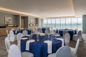 巴拿马城Residence Inn by Marriott Panama City的一间会议室,配有蓝色的桌子和白色的椅子
