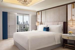雅加达The St. Regis Jakarta的卧室设有一张白色大床和大窗户