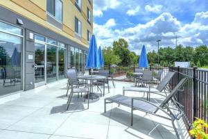 格林维尔Fairfield Inn & Suites by Marriott Greenville的一个带桌椅和蓝伞的庭院