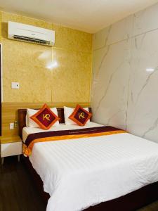 Quảng TrịKhách sạn Khánh Phương的一间卧室配有一张带红色枕头的床