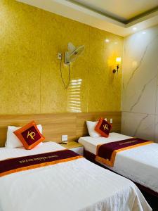 Quảng TrịKhách sạn Khánh Phương的一间设有两张橙色和白色床单的房间