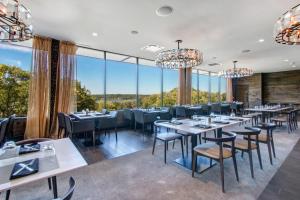 日内瓦湖YOUR New Luxury Lakeview Condo w Pool Access的餐厅设有桌椅和大窗户。