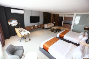 利帕Solano Hotel的酒店客房设有两张床和一台平面电视。