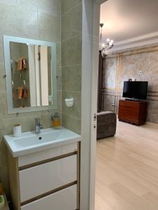 阿克托比Апартаменты в районе Болашак的客房内设有带水槽的浴室和电视