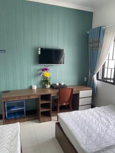 朱笃Kim Ngân Motel的一间卧室配有一张桌子、一台电脑和一张床