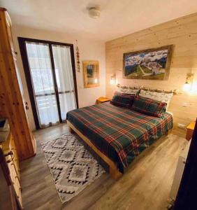 塔尔维西奥A casa di Gerry的一间卧室配有一张带铺着平底毯的床