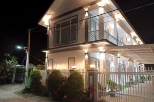 贡布Cambodian SUN Guesthouse的一间白色的大房子,晚上有灯