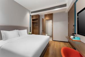 南宁南宁会展中心智选假日酒店的卧室配有白色的床和红色椅子
