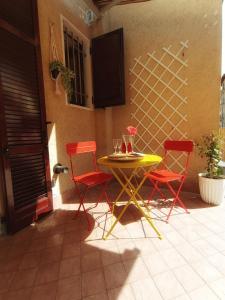 圣佩莱格里诺温泉Baciati dal Sole-Self check-in的天井上摆放着一张黄色桌子和两张红色椅子