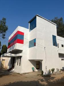 RāmtekHotel Tathastu的白色的建筑,红色和蓝色