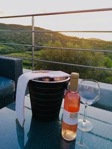 圣弗洛朗Hôtel - Restaurant U Santu Petru的一瓶葡萄酒和一张桌子上的一杯
