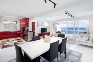 斯卡伯勒Scarborough Waterfront Penthouse Unit的厨房以及带白色桌椅的起居室。
