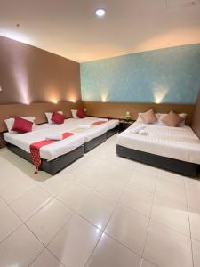 瓜拉丁加奴DJ西迪点酒店的一间卧室配有两张带红色枕头的床