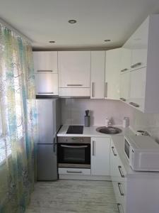 陶格夫匹尔斯Comfort的白色的厨房配有水槽和冰箱