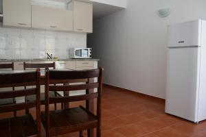 卡拉帕泰拉Casa da Praia do Amado的厨房配有桌椅和冰箱。