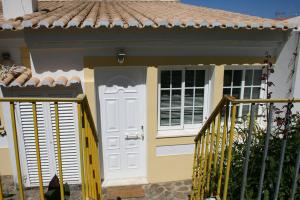 卡拉帕泰拉Casa da Praia do Amado的白色门和门的房子