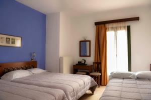 特尔斐阿尔特弥斯酒店的一间卧室设有两张床和窗户。
