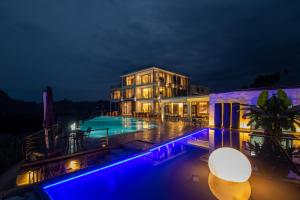 张家界XMAN Valley Sunrise Resort的一座大型建筑,晚上设有游泳池