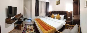 甘托克Hotel Yangbum的配有一张床和一台平面电视的酒店客房