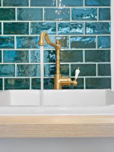 悉尼VENUS Central Sydney - FEMALE ONLY HOSTEL的浴室水槽配有黄铜水水龙头