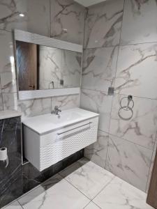 莫纳斯提尔Palm lake resort Folla Monastir的浴室设有白色水槽和镜子