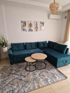 莫纳斯提尔Palm lake resort Folla Monastir的客厅配有蓝色的沙发和桌子