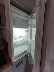 弗里茨拉尔Apartment Maiglöckchen的厨房里空着冰箱,门开