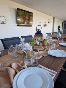 Къща за гости Вила Победа的一张木桌,上面有盘子和玻璃杯