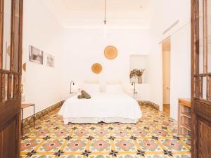桑特略伦斯斯德斯卡尔达萨尔Hotel Boutique Can Pocovi的卧室配有白色的床和图案地板