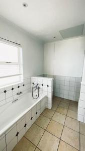 莫塞尔湾Luxury Lodge at Pinnacle Point的白色的浴室设有浴缸和窗户。