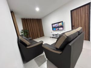 古晋Armadale Residence-Gala City的客厅设有两把椅子,配有电视