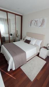 维戈Val do Fragoso的卧室配有一张白色大床和镜子