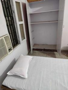 巴特那OYO Swaraj Guest House的窗户客房内的一张白色床