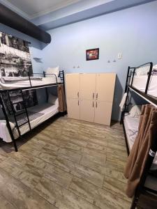 第比利斯Tbil Home Hostel的客房设有两张双层床,铺有木地板。