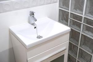 哈恩Slappe Jaén II的浴室设有玻璃瓷砖,配有白色水槽。