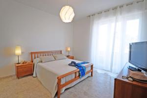 波尔图圣乔治Appartamento Bellariva A1 - MyHo Casa的一间卧室配有一张床和一台平面电视