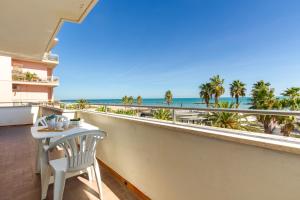 波尔图圣乔治Appartamento Bellariva A1 - MyHo Casa的阳台配有桌子,享有海滩美景