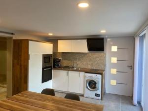 米提莫里Appartement 2 pièces cozy au calme的厨房配有白色橱柜、洗衣机和烘干机