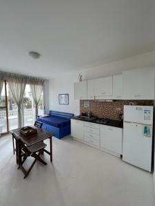 萨尔雷Útulný apartmán na Praia de Chaves, Boa Vista的白色的厨房配有桌子和冰箱