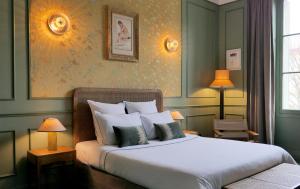 波城Hôtel Bristol Pau的一间卧室配有一张带两盏灯的大型白色床。