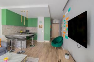 布达佩斯BudapestStyle Superior Family Apartman, Private Parking, Breakfast的客厅设有绿色橱柜和墙上的电视
