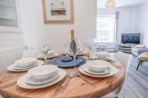 滕比Canol Y Bryn - 3 Bedroom Holiday Home - Tenby的餐桌,配有盘子和酒杯